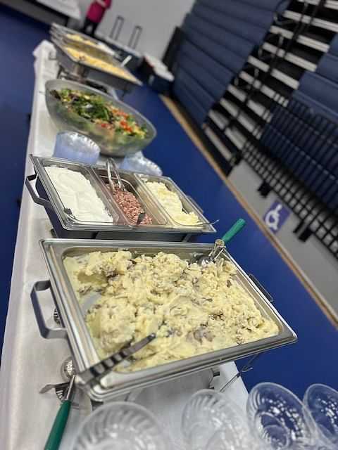 Buffet line with various dishes, salad, and serving utensils.